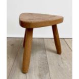 A Robin Nance elm milking stool, with triangular seat and three turned legs, stamped NANCE WORKSHOPS