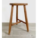 A Robin Nance pine bar stool, the triangular seat upon three chamfered legs united by a stretcher,