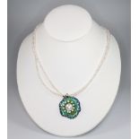 A silver necklace set with pearls and enamel on a pearl necklace