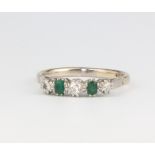 An 18ct white gold emerald and diamond ring, the 3 brilliant cut diamonds approx. 0.17ct, the 2 oval