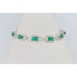 An 18ct white gold emerald and diamond line bracelet, the emeralds approx. 7.63ct, the brilliant cut