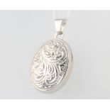 A 9ct white gold engraved oval locket 2.6 grams gross, 25mm