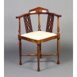 An Edwardian inlaid mahogany corner chair with pierced slats to the side, raised on turned
