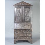 A 19th Century carved oak bureau bookcase, the associated top with pediment and dentilled cornice,