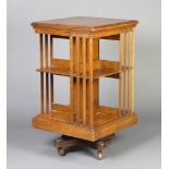 An Edwardian square light oak 2 tier revolving bookcase 85cm h x 49cm w x 50cm d Some light