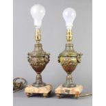 A pair of 19th Century gilt spelter and marble lidded urns raised on square marble bases converted