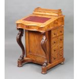 A Victorian figured walnut Davenport of serpentine outline, having a stationery box top with 3/4