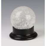 A white mottled glass "crystal ball" 12cm on a wooden stand