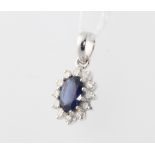 An 18ct white gold oval sapphire and diamond cluster pendant, sapphire approx. 1.02ct, diamonds 0.