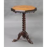 A Victorian octagonal walnut finished and ebonised snap top wine table raised on a spiral turned