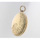 A 9ct yellow gold oval locket with engraved decoration 35mm, 3.6 grams