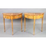 A pair of Georgian style inlaid and crossbanded yew demi-lune tables fitted dummy drawer, raised