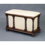 A Victorian rectangular rosewood ottoman with hinged lid raised on spiral turned supports, bun