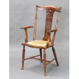 An Edwardian Art Nouveau turned beech slat back open armchair raised on turned supports with