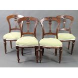 A set of 4 Victorian carved mahogany spoon back dining chairs with vase shaped slat backs and over