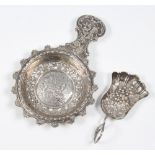 A George III repousse silver caddy spoon, the bowl decorated with grapes and vines, Birmingham 1810,