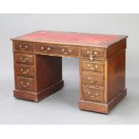 A Victorian walnut kneehole desk with red leather inset writing surface above 1 long and 8 short