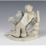 A Lladro matt figure of a boy seated beside a tree trunk 24cm