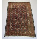 A brown and red ground belouche rug with all over floral design within a multi row border 176cm x