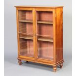 A Victorian mahogany bookcase, fitted shelves enclosed by glazed panelled doors, raised on bun