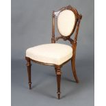 A Victorian carved walnut show frame chair with upholstered seat and back, raised on turned and