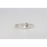 A 9ct white gold 11 stone baguette diamond crossover ring, approx. 0.15ct, 2.3 grams, size R