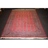 A red ground Bokhara carpet with numerous octagons to the centre within a multi row border 368cm x
