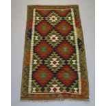 A brown and tan ground Kilim rug with all over diamond design 197cm x 102cm
