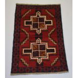 A brown, red and blue ground Baluchi rug with 2 stylised diamonds to the middle 136cm x 86cm