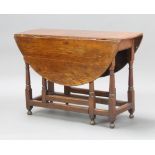 An 18th Century oak oval drop flap gateleg dining table fitted a frieze drawer, raised on turned
