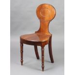 A Georgian mahogany hall chair with oval back and shaped seat raised on turned supports