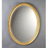 A 19th Century oval bevelled plate wall mirror contained in a decorative gilt frame 69cm h x 51cm