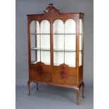 An Edwardian shaped mahogany display cabinet, the upper section with arched top, fitted shelves