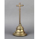 A Victorian brass door stop with cruciform handle and bell shaped base 30cm h x 14cm w x 7cm d