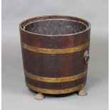 An Edwardian circular coopered oak log bin with brass ring mask handles, raised on paw feet complete