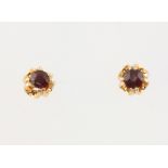 A pair of 9ct yellow gold garnet ear studs 5mm, 0.9 grams