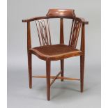 An Edwardian inlaid mahogany corner chair with pierced slat back and upholstered seat, raised on