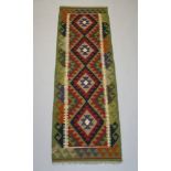 A black, tan and red ground Maimana Kilim runner with 4 stylised diamonds to the centre centre 207cm