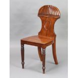 A Regency shaped mahogany hall chair with solid seat raised on turned and reeded supports Split to