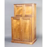 An Edwardian Art Nouveau mahogany cabinet on cabinet, both sections with cupboards enclosed by