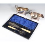 Two silver plated sauce boats and a pair of cased plated fish servers
