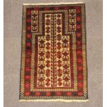 A red and tan ground Baluchi prayer rug 128cm x 83cm