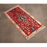 A North West Persian red and blue ground rug with central medallion with a 3 row border 230cm x