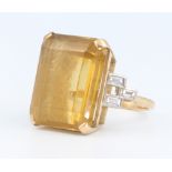An 18ct yellow gold citrine dress ring 20mm x 15mm, each shoulder with 3 baguette cut diamonds