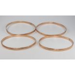 Four 14ct yellow gold engraved bangles, 35 grams