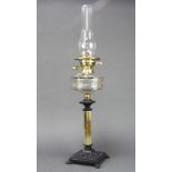 A Victorian faceted glass oil lamp reservoir, raised on a reeded brass and cast iron base complete