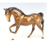 A Royal Doulton figure of a horse with right leg raised, gloss brown, 29cm