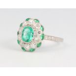 A platinum oval emerald and diamond cluster ring, the centre emerald approx. 0.79ct surrounded by
