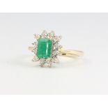 A 9ct yellow gold rectangular emerald and diamond cluster ring, the centre stone 0.98ct, the