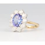 An 18ct yellow gold oval tanzanite and diamond cluster ring, the centre cut stone approx. 2.4ct